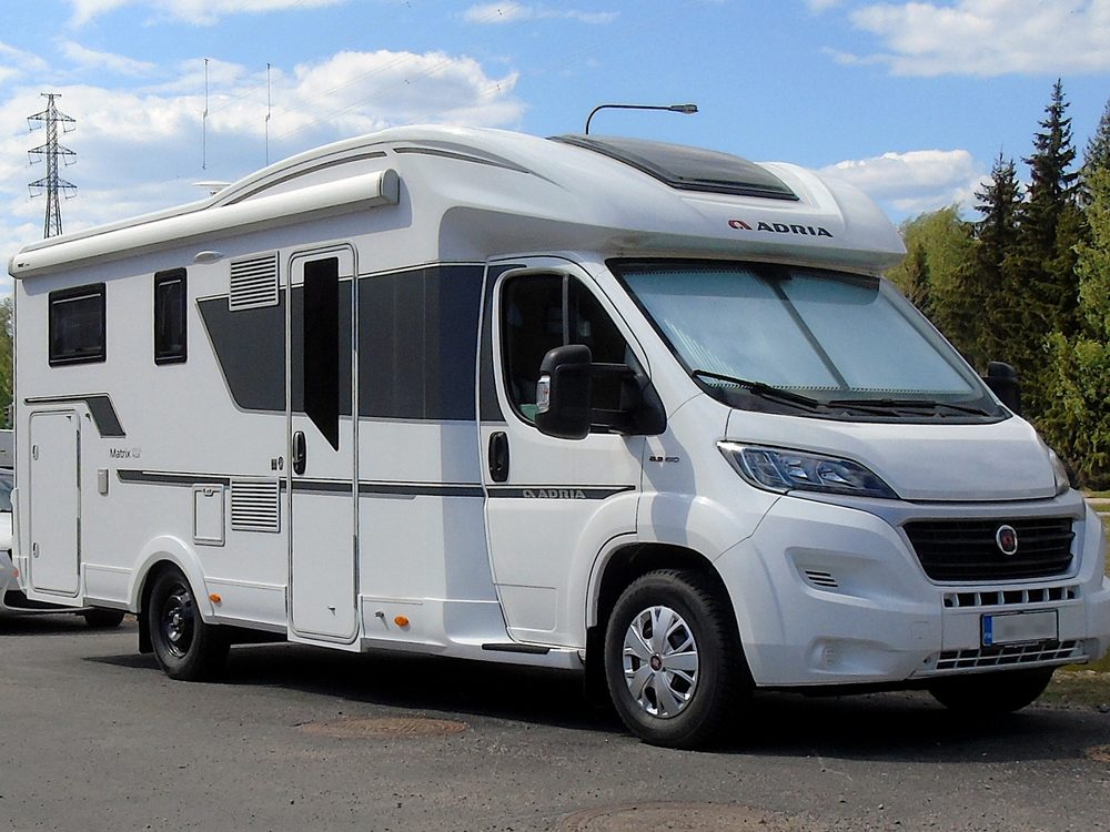 A white Adria motorhome parked on a paved lot