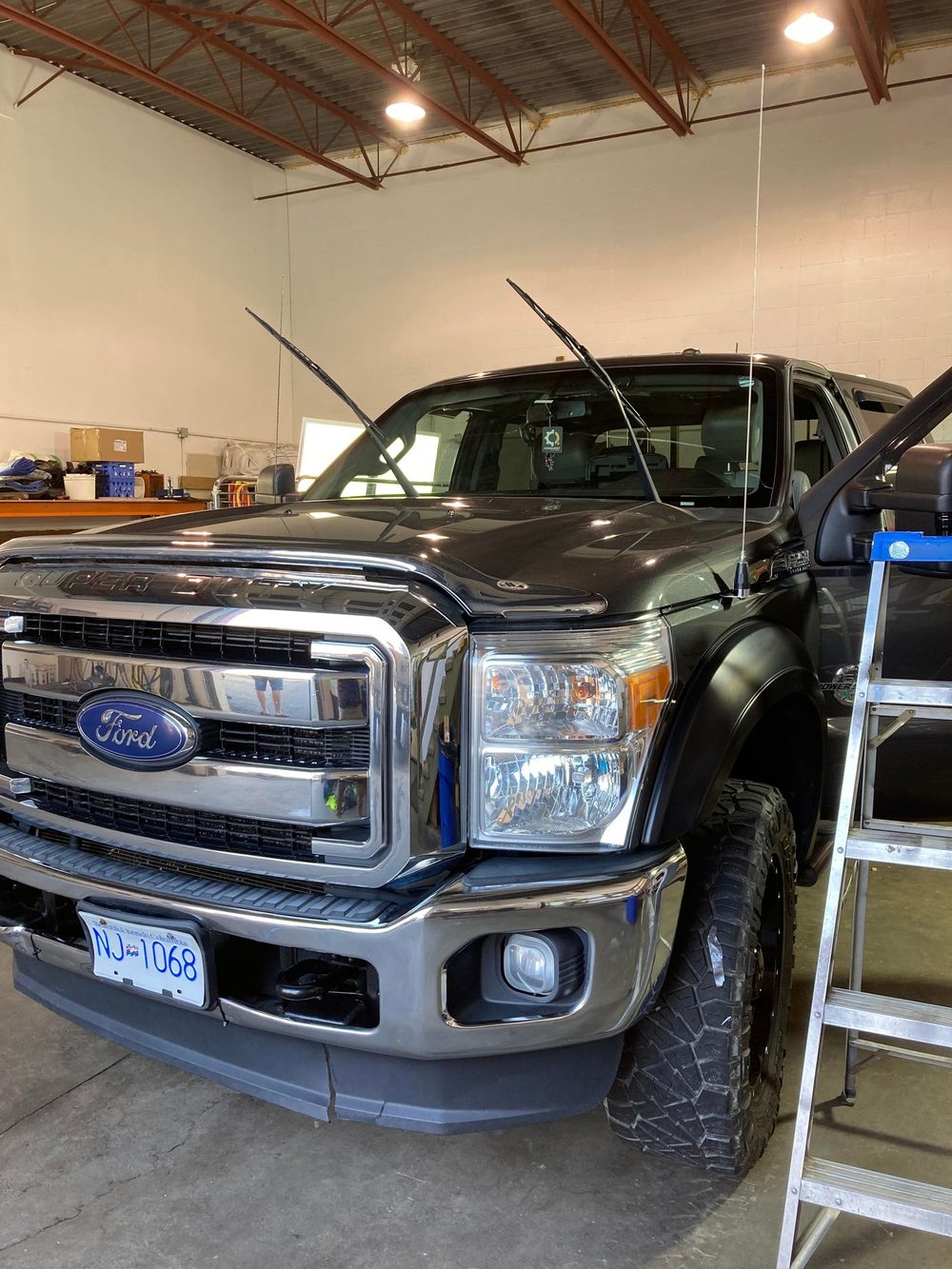 A black Ford F-250 Super Duty inside the Walker Mobile Detailing shop bay after coating